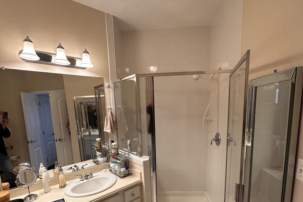 Before — The vanity wall and the corner shower.