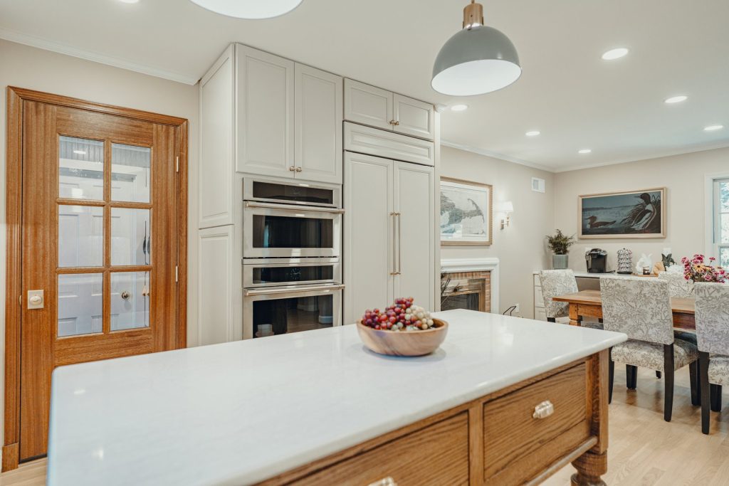 Glazed pantry door and quartz island in a remodeled Bethesda kitchen