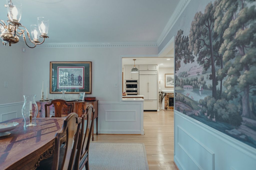 Dining room with wainscot panelling and a mural beside the remodeled Bethesda kitchen
